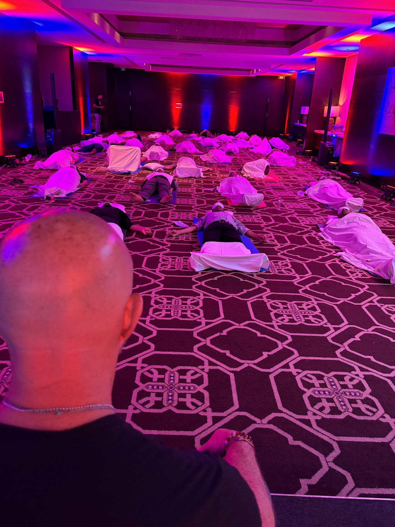 A room of founders lying on mats during a Deep End group breathwork session